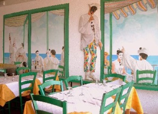 La sala ed i tavoli del Ristorante con dietro raffigurato l'immagine del Pierrot che invita al silenzio mentre si mangia